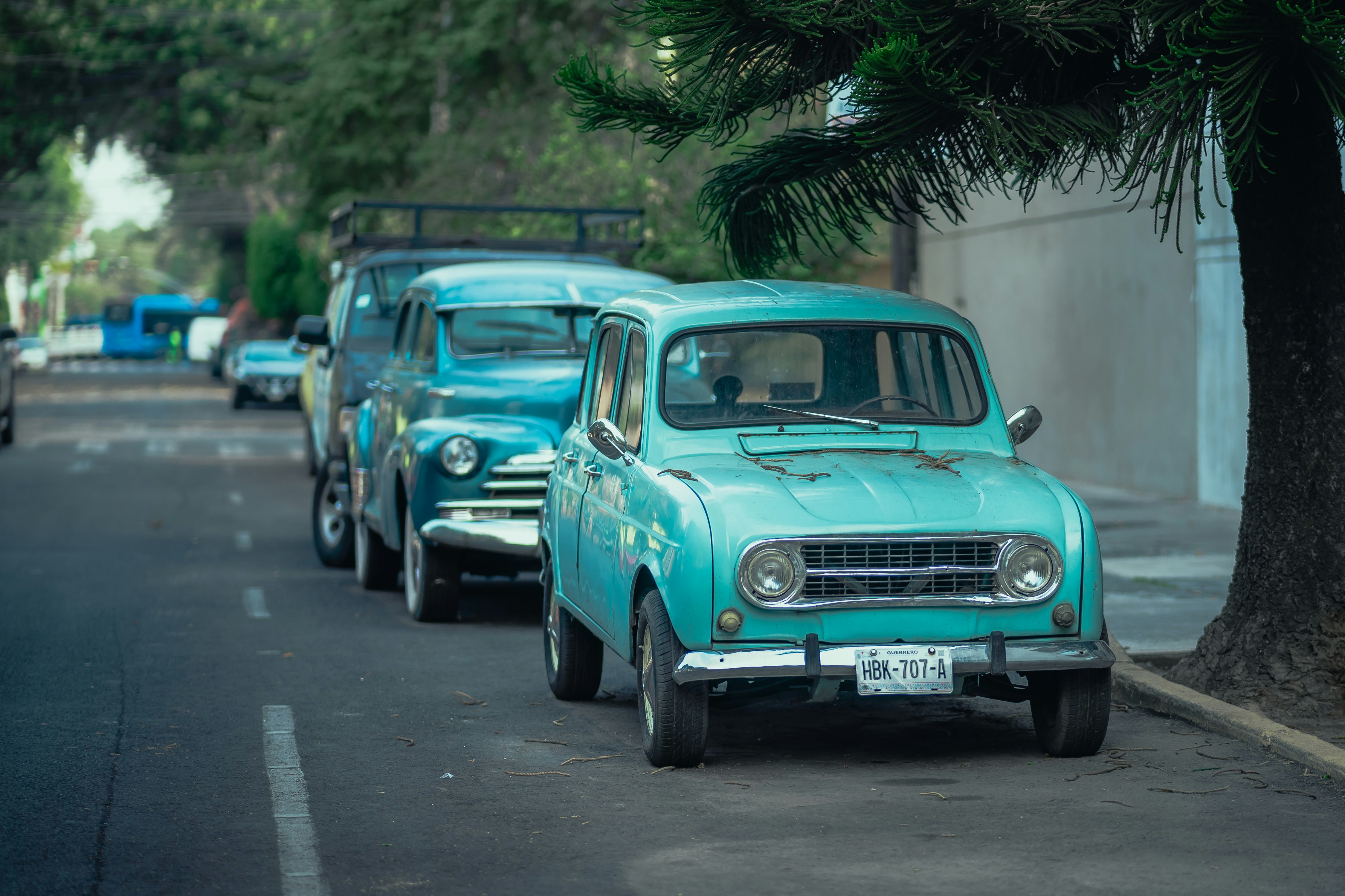 blue classic car parked on the side of the road